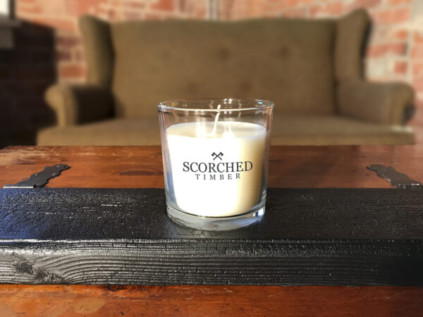 Scorched Timber candle in brick apartment near a green couch